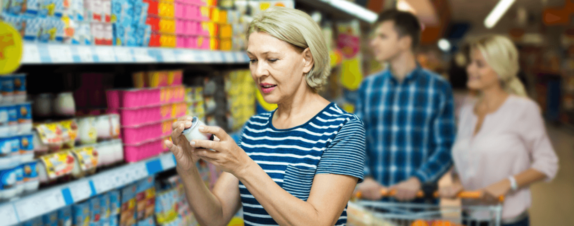 woman looking at labels in grocery aisle